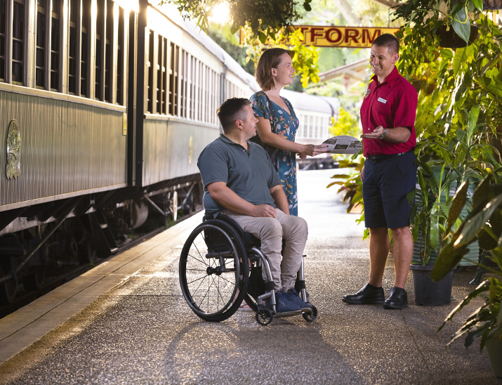 A man in a wheelchair next to a train