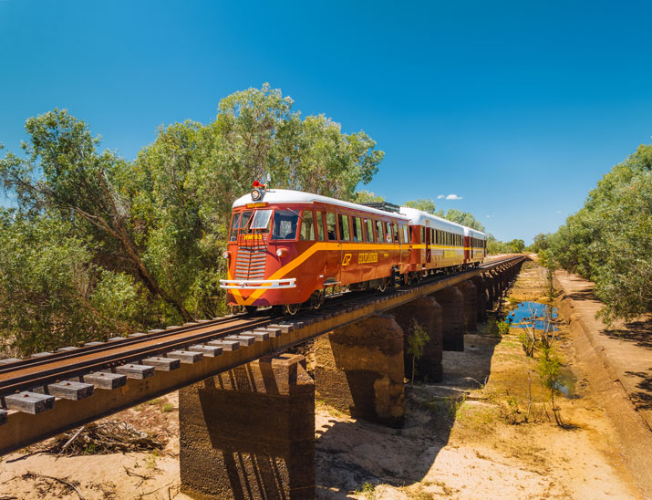 A couple step onto a train platform from the Savannahlander train