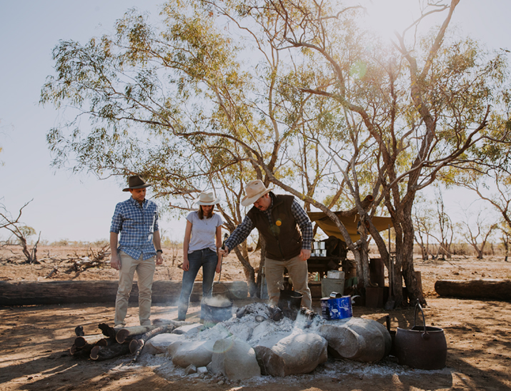 Travellers enjoying a campfire and billy tea